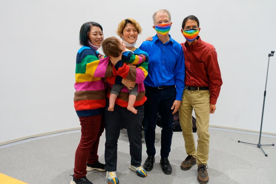 Same-sex couples from left; partners Satoko Nagamura and Mamiko Moda and their son Ittan, and John Lewis and Stuart Gaffney pose for photos after the press conference marking the first day of Tokyo's recognition for partnerships, Tuesday, Nov. 1, 2022, in Tokyo, Japan.