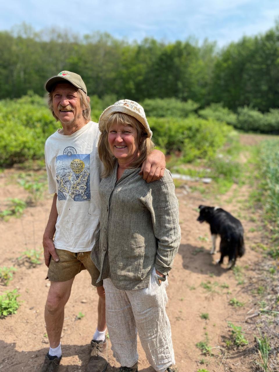 Tom Galazen and Ann Rosenquist stand with their dog among North Wind Organic Farm, which they operate near Bayfield.