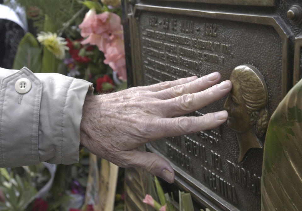 FILE - In this July 26, 2002, file photo, a man touches the tomb of Maria Eva Duarte de Peron at Recoleta cemetery in Buenos Aires, Argentina. Sites associated with Eva Peron remain top attractions for many tourists in Buenos Aires. (AP Photo/Eduardo Di Baia, File)