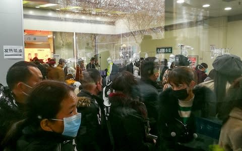 People queue for receiving treatment at the fever outpatient department at the Wuhan Tongji Hospital  - Credit: Reuters