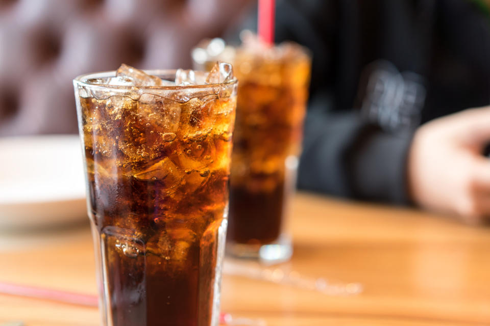 Soft drink on wooden table and men sitting