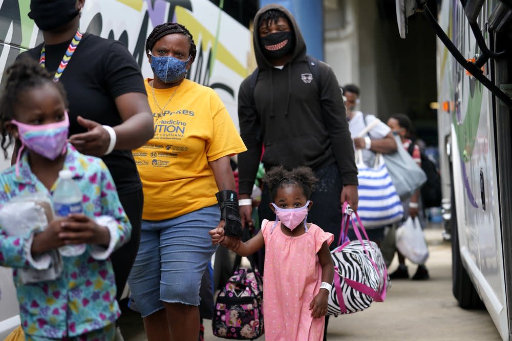 Shawn Nelson, 7, right, and Asia Nelson, 6, left, board a bus to evacuate Lake Charles, La., Wednesday, Aug. 26, 2020, ahead of Hurricane Laura. (AP Photo/Gerald Herbert)