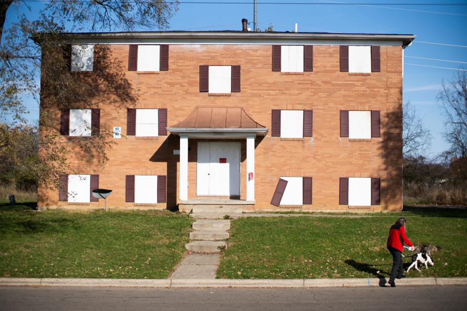 Nov 9, 2023; Columbus, OH, USA; A women walks her dog in Colonial Village on the East side, where over 850 Haitian immigrants are living in mostly abandoned apartments. They were scammed into moving in and paying $1,200 for two bedroom apartments without heat, hot water, and some without electricity.