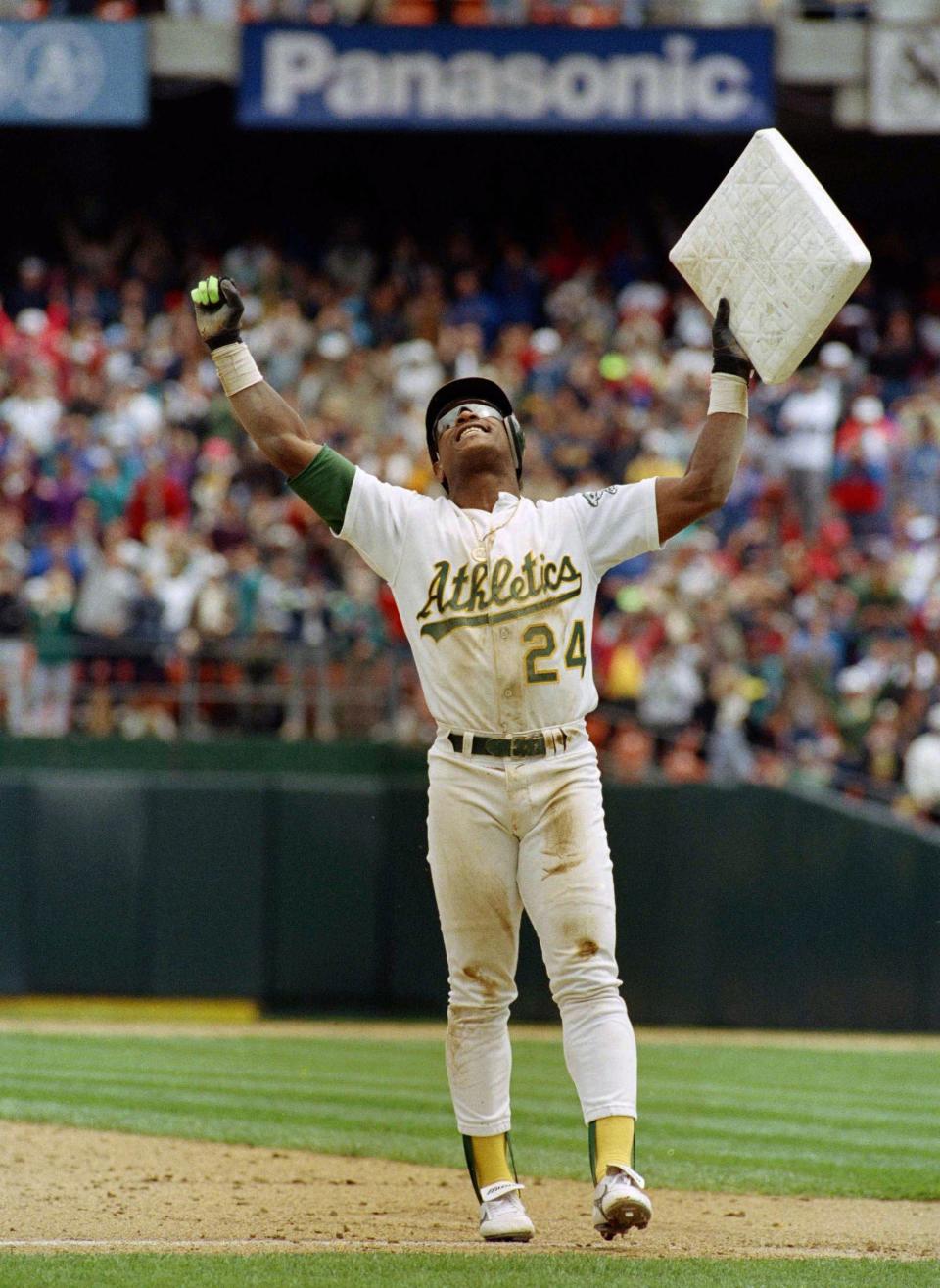 Rickey Henderson celebrates and raises third base after setting the all-time stolen base record.