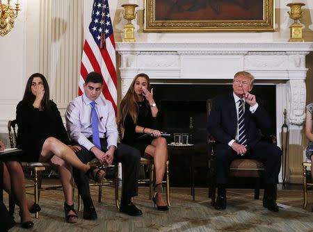 Marjory Stoneman Douglas High School shooting mother Melissa Blank (L) and surviving students Jonathan Blank (2nd L) and Julia Cordover (3rd L) react along with U.S. President Donald Trump as they listen to survivors and the relatives of victims during a listening session with high school students, family members and teachers to discuss school safety and shootings at the White House in Washington, U.S., February 21, 2018. REUTERS/Jonathan Ernst