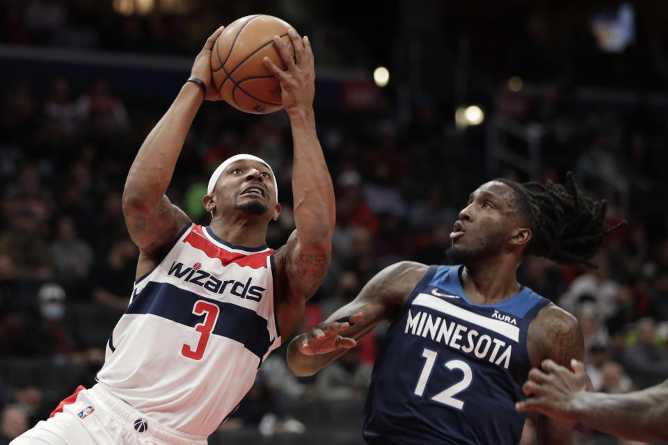 Washington Wizards' Bradley Beal (3) moves the ball on Minnesota Timberwolves' Taurean Prince (12) during the first half of an NBA basketball game Wednesday, Dec. 1, 2021, in Washington. (AP Photo/Luis M. Alvarez)