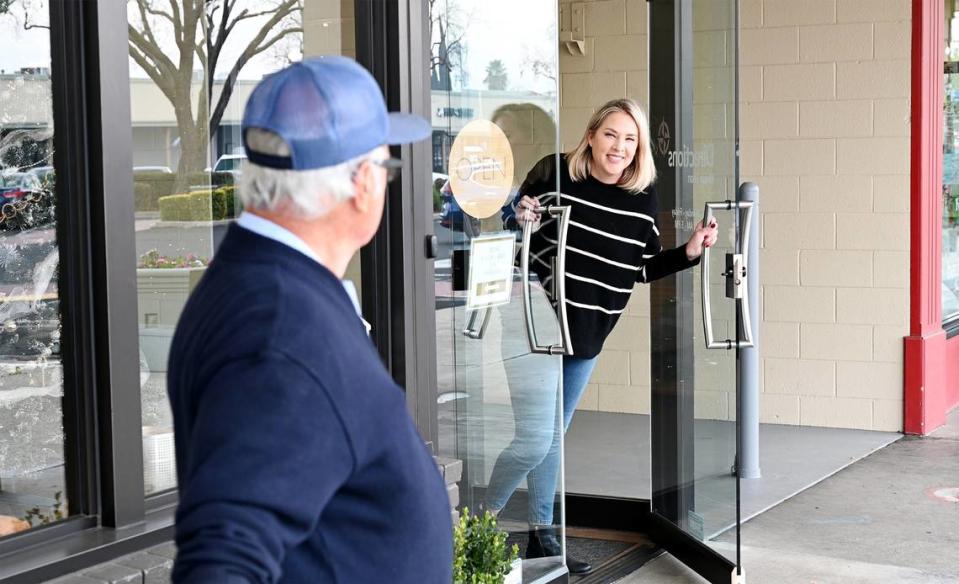 El cartero Dave Costa habla con Lauren Morris, de Directions Home Loan, mientras reparte el correo en McHenry Village en Modesto, California, el miércoles 27 de diciembre de 2023.