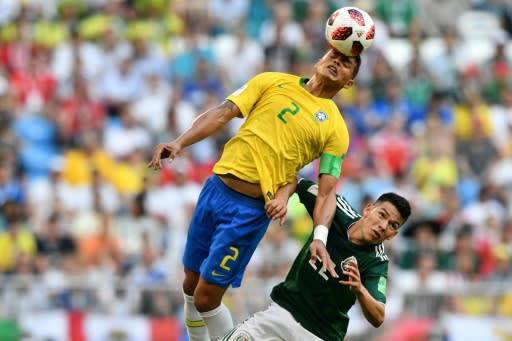 Leading from the back: captain Thiago Silva wins a high ball against Hirving Lozano in Brazil's win over Mexico