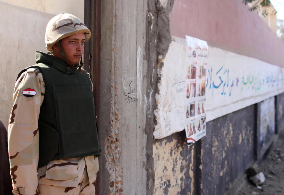 An Egyptian soldier stands at a polling station during the constitutional referendum in Dalga village of Minya, Egypt, Wednesday, Jan. 15, 2014. Through violence or intimidation, Islamists in villages like this one used violence or intimidation to stop Christians from voting "no" to a 2012 constitution that had paved the way for the creation of an Islamic state. This time around, no one is stopping the Christians and they are voting "yes" on a new charter that criminalizes discrimination and instructs the next legislature to ease restrictions on building churches. (AP Photo/Roger Anis, El Shorouk Newspaper) EGYPT OUT