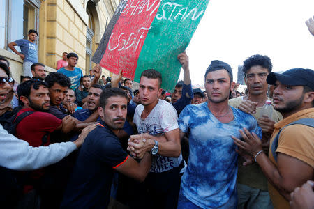 FILE PHOTO: A group of migrants try to make their way through the crowd to the Keleti Railway station in Budapest, Hungary, September 2, 2015. REUTERS/Laszlo Balogh/File Photo