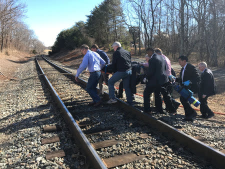 Emergency first responders and passengers from an Amtrak passenger train carrying Republican members of the U.S. Congress from Washington to a retreat in West Virginia carry one of the injured across train tracks to an ambulance after the train collided with a garbage truck in Crozet, Virginia, U.S. January 31, 2018. Justin Ide/Crozet Volunteer Fire Department/Handout via REUTERS