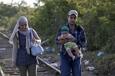 A migrant family, hoping to cross into Hungary, walk along a railway track near the village of Horgos in Serbia, towards the border it shares with Hungary, September 1, 2015. REUTERS/Marko Djuricaâ€¨