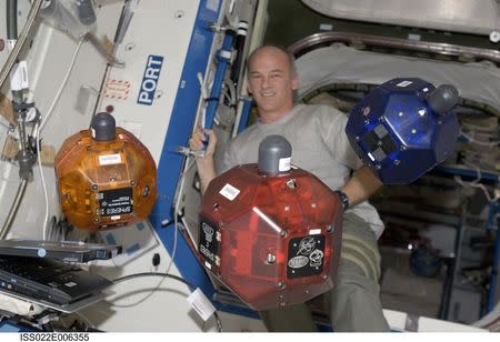 NASA astronaut Jeffrey Williams, Expedition 22 commander, performs a check of the Synchronized Position Hold, Engage, Reorient, Experimental Satellites (SPHERES) Beacon / Beacon Tester in the Destiny laboratory of the International Space Station in this December 5, 2009 NASA handout photo released to Reuters July 3, 2014. REUTERS/NASA/Handout via Reuters