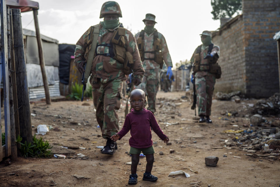 South African National Defense Forces patrol the Sjwetla informal settlement after pushing back residents into their homes, on the outskirts of the Alexandra township in Johannesburg, Monday, April 20, 2020. The residents were protesting the lack of food. Many have lost their income as South Africa is under a strict five-week lockdown in a effort to fight the coronavirus pandemic. (AP Photo/Jerome Delay)