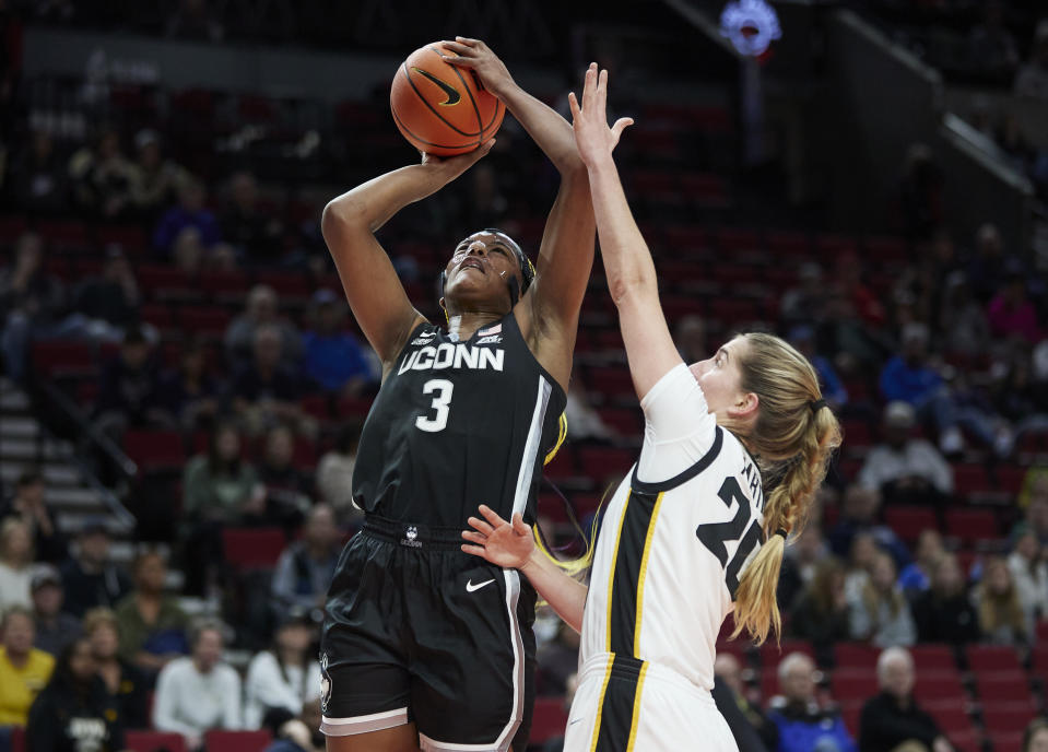 UConn forward Aaliyah Edwards, left, shoots over Iowa guard Kate Martin during the first half of an NCAA college basketball game in the Phil Knight Legacy Championship in Portland, Ore., Sunday, Nov. 27, 2022. (AP Photo/Craig Mitchelldyer)