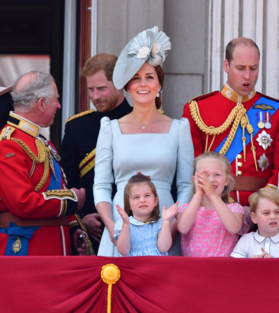 Prince Charles, Prince Harry, Kate Middleton, Prince William, and Princess Charlotte stand on a porch.