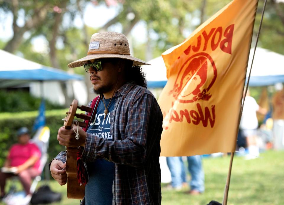 Adrian Alcantar, of Immokalee, warms up before playing Son jarocho, a style of Mexican folk music, during the Farmworker Freedom Festival at Bradley Park on Saturday.
