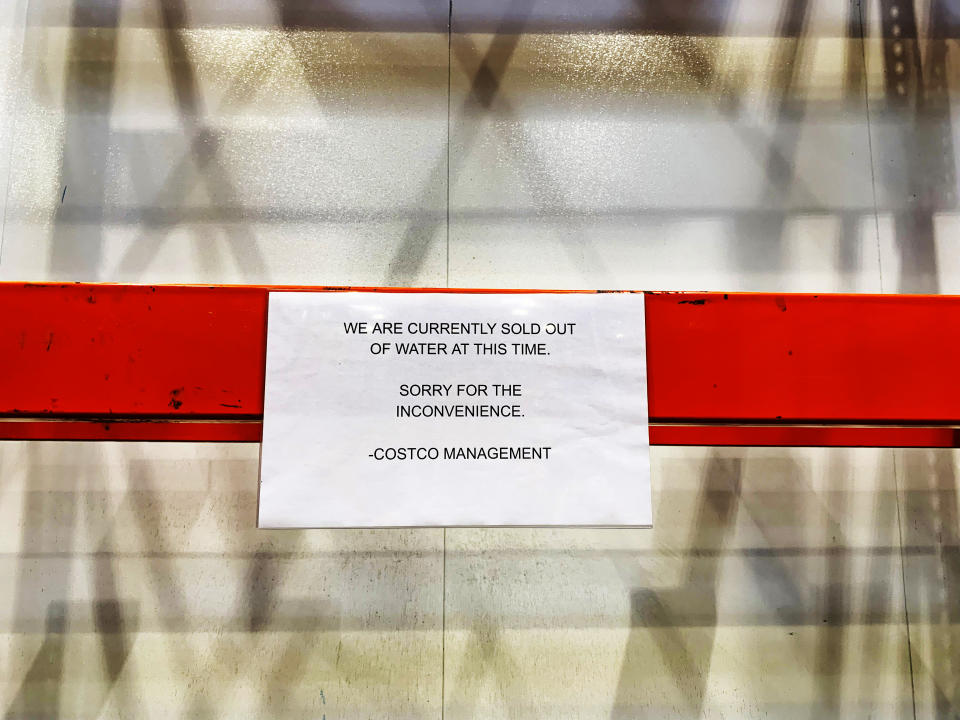 Empty shelves are seen with a sign at Costco stating that the retailer is currently sold out of water ahead of Hurricane Dorian on Thursday, Aug. 29, 2019, in Davie, Fla. (AP Photo/Brynn Anderson)