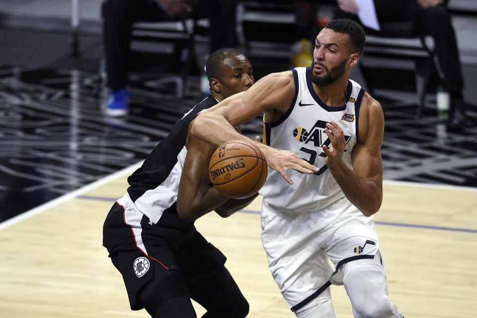 Utah Jazz center Rudy Gobert, right, loses the ball while driving to the basket as Los Angeles Clippers center Serge Ibaka defends during the first half of an NBA basketball game in Los Angeles, Friday, Feb. 19, 2021. (AP Photo/Kelvin Kuo)