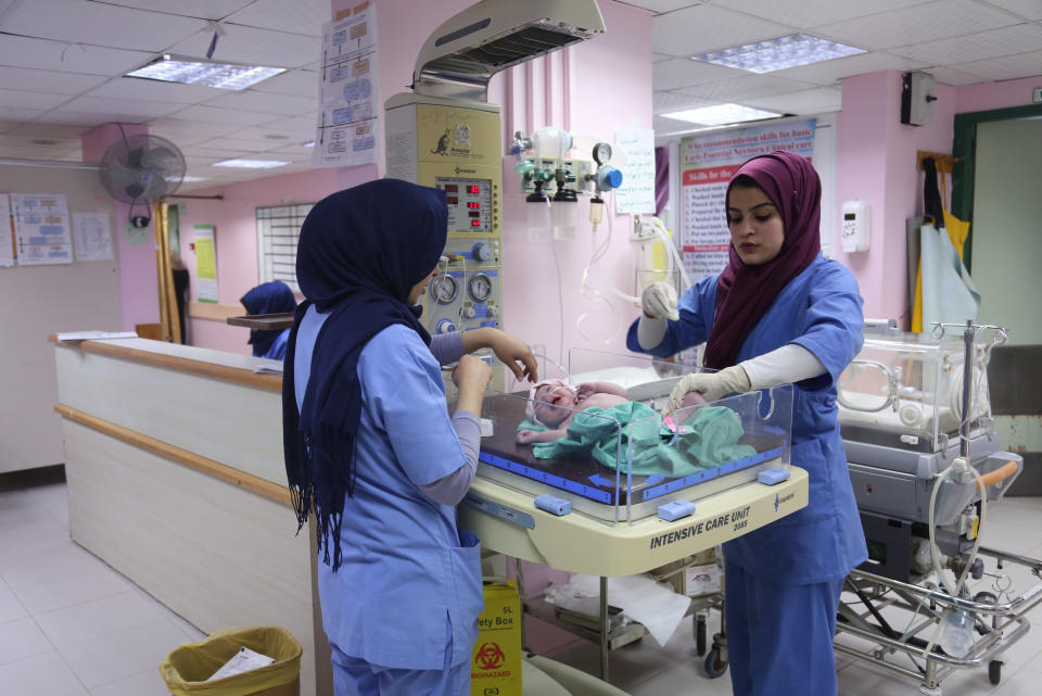 Palestinian midwife Sara Abu Taqea (R), 23, who works in the maternity ward at Gaza's Al-Ahli hospital, weighs a newborn at the hospital in Gaza City, Feb. 10, 2019. Abu Taqea said she found temporary work in a Gaza hospital after finishing a bachelor's degree in midwifery, but that many of her colleagues were not so lucky. "It is a six-month contract, with no guarantee of further employment," she said. (Photo: Samar Abo Elouf/Reuters)    