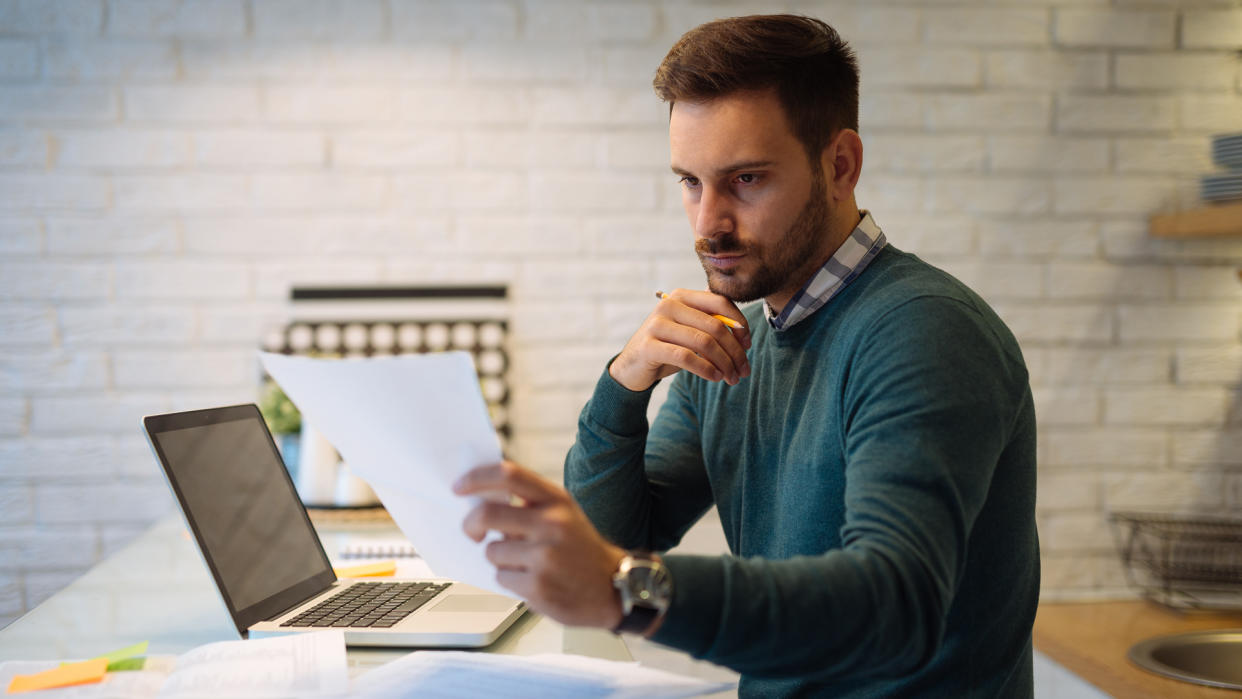 Male businessman working at home on a computer.