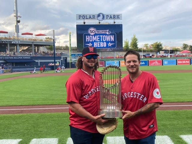 Jarrod Saltalamacchia and Jake Peavy hold the 2013 World Series championship trophy before Tuesday night's game at Polar Park.