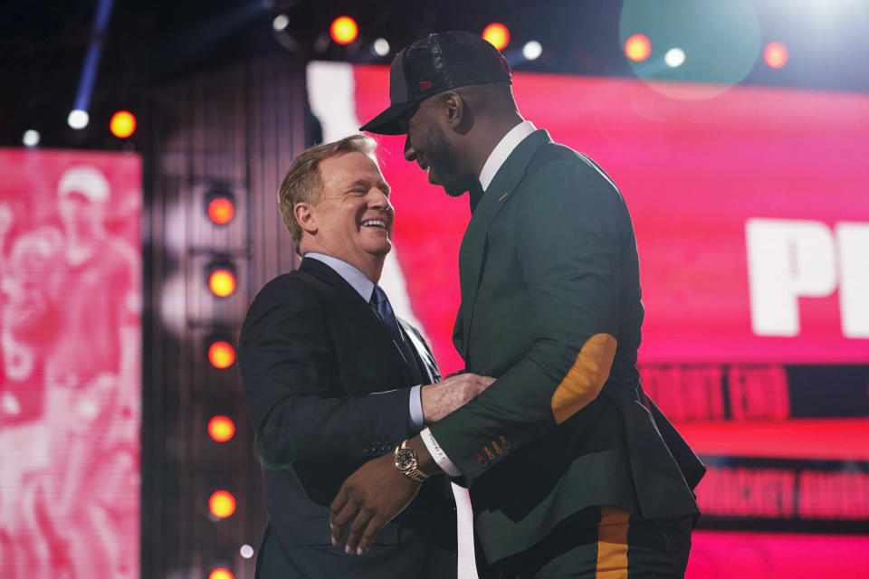 Florida tight end Kyle Pitts, right, is greeted by NFL Commissioner Roger Goodell after he was chosen by the Atlanta Falcons with the fourth pick in the NFL football draft Thursday, April 29, 2021, in Cleveland. (AP Photo/Tony Dejak)