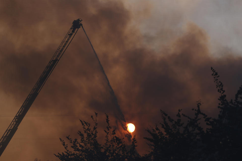 A grass fire seen Monday, Aug. 26, 2019 has burned at least two buildings, prompted evacuations, and shut down multiple roads in Northeast Portland.(Beth Nakamura/The Oregonian via AP)