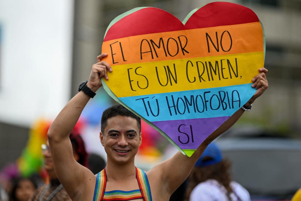 A reveler holds a sign in the shape of a heart reading "Love is Not a Crime, But Your Homophobia Is" during the Pride Parade in Guatemala City on Saturday.