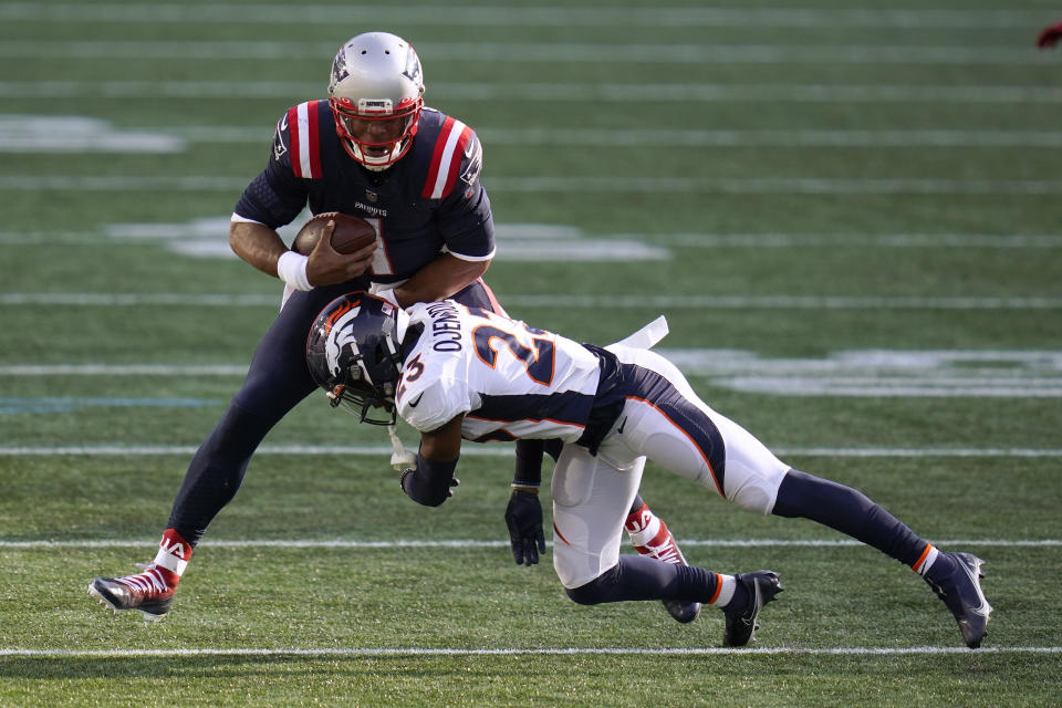 Denver Broncos cornerback Michael Ojemudia, front, tackles New England Patriots quarterback Cam Newton after catching a pass by wide receiver Julien Edelman in the second half of an NFL football game, Sunday, Oct. 18, 2020, in Foxborough, Mass. (AP Photo/Charles Krupa)