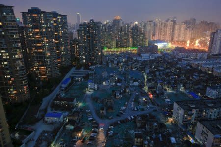 FILE PHOTO: A night view of the old houses surrounded by new apartment buildings at Guangfuli neighbourhood in Shanghai, China, April 10, 2016. I  REUTERS/Aly Song/File Photo