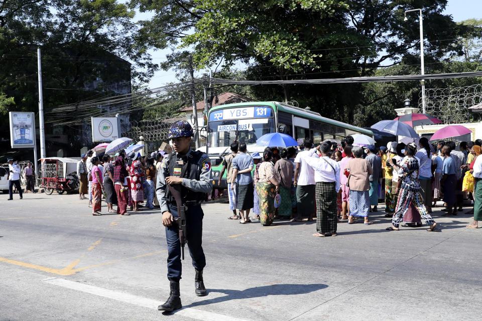 A police provides security while a bus carrying released prisoners is welcomed by family members and colleagues as it leaves Insein Prison in Yangon, Myanmar, Thursday, Jan. 4, 2024. Myanmar’s military government on Thursday pardoned nearly 10,000 prisoners to mark the 76th anniversary of gaining independence from Britain, but it wasn’t immediately clear if any of those released included the thousands of political detainees jailed for opposing army rule.(AP Photo/Thein Zaw)
