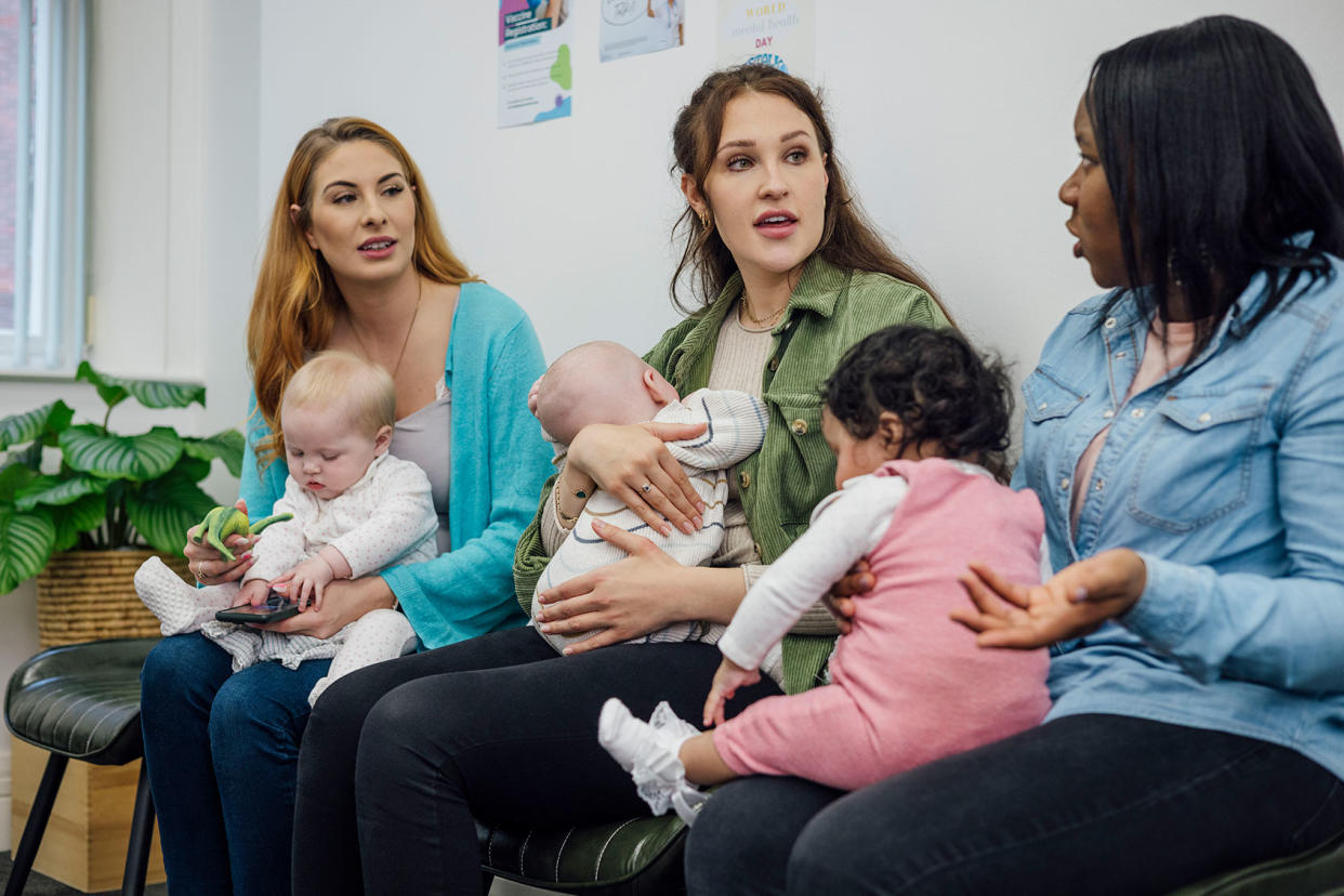 A shot of a group of women sitting together with their babies in the waiting room of a baby clinic Getty Images/SolStock
