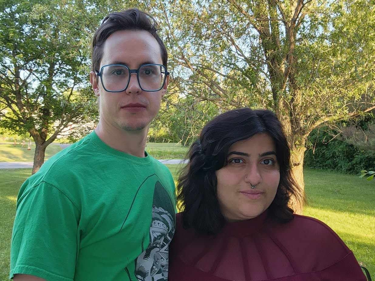Sara Ali and partner, Sean. They are standing outside in a park and looking at the camera.