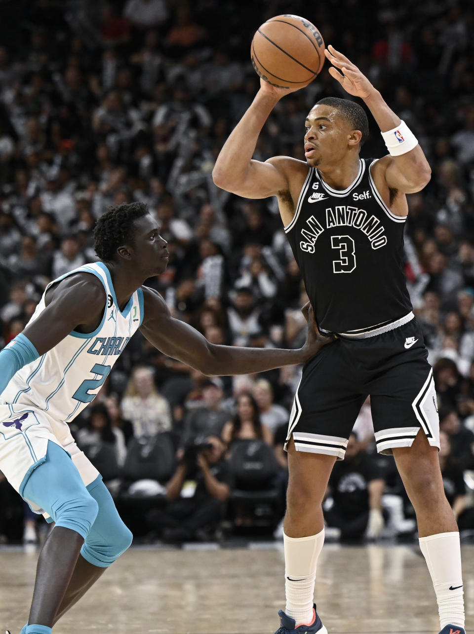 San Antonio Spurs' Keldon Johnson (3) looks to pass as he is defended by Charlotte Hornets' J.T. Thor during the second half of an NBA basketball game, Wednesday, Oct. 19, 2022, in San Antonio. Charlotte won 129-102. (AP Photo/Darren Abate)