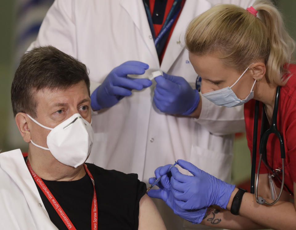 Waldemar Wierzba,left, the director of the Interior Ministry hospital in Warsaw, the capital's main COVID-19 hospital, is getting the coronavirus vaccination in Warsaw, Poland, Sunday Dec. 27, 2020. Wierzba was the second person to be vaccinated in Poland as part of a European Union rollout on Sunday. (AP Photo/Czarek Sokolowski)