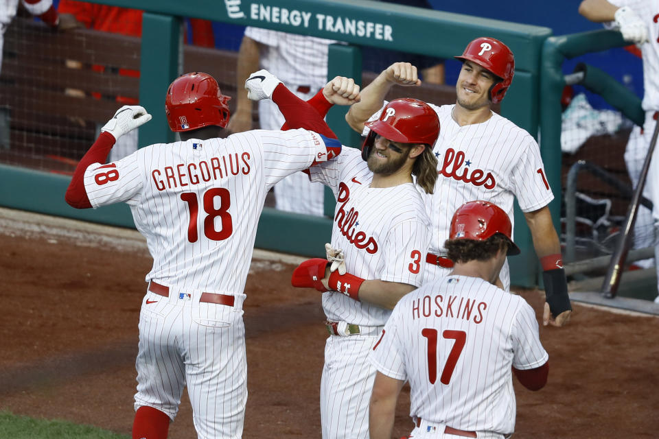 Philadelphia Phillies' Didi Gregorius (18) celebrates with Bryce Harper (3), J.T. Realmuto (10) and Rhys Hoskins (17) after hitting a grand slam off Atlanta Braves pitcher Robbie Erlin during the sceond inning of a baseball game, Monday, Aug. 10, 2020, in Philadelphia. (AP Photo/Matt Slocum)