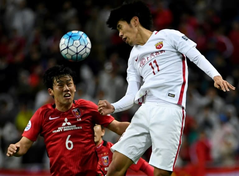 Shanghai SIPG' Lyu Wenjun (R) heads the ball next to Urawa Red Diamonds' Tomoaki Makino during their AFC Champions League match in Saitama, in April 2017