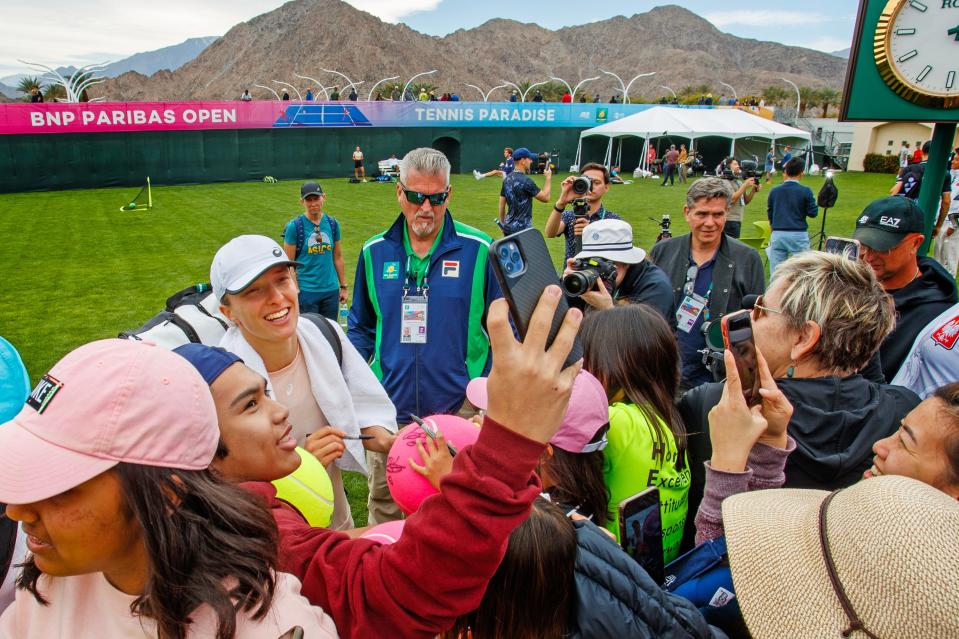 Defending champion Iga Swiatek takes photos with fans during day one of the BNP Paribas Open at the Indian Wells Tennis Garden in Indian Wells, Calif., on Monday, March 6, 2023.