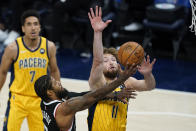 Los Angeles Clippers' Paul George (13) puts up a shot against Indiana Pacers' Domantas Sabonis (11) during the first half of an NBA basketball game, Tuesday, April 13, 2021, in Indianapolis. (AP Photo/Darron Cummings)