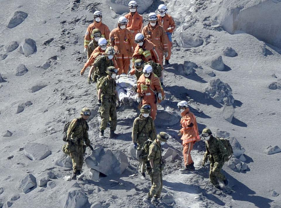 Japan Self-Defense Force (JSDF) soldiers and firefighters carry an injured person near a crater of Mt. Ontake, which straddles Nagano and Gifu prefectures in this September 28, 2014 photo taken and released by Kyodo. More than 500 Japanese military and police set out on Sunday to search the peak of a volcano popular with hikers a day after its sudden eruption trapped hundreds on the mountain for hours, amid conflicting reports about missing and injured climbers. Mandatory credit. REUTERS/Kyodo (JAPAN - Tags: DISASTER ENVIRONMENT SOCIETY) ATTENTION EDITORS - THIS IMAGE HAS BEEN SUPPLIED BY A THIRD PARTY. THIS PICTURE WAS PROCESSED BY REUTERS TO ENHANCE QUALITY. AN UNPROCESSED VERSION WILL BE PROVIDED SEPARATELY. MANDATORY CREDIT. JAPAN OUT. NO COMMERCIAL OR EDITORIAL SALES IN JAPAN. YES