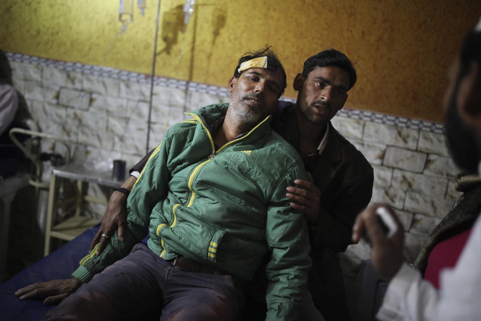 In this Friday, Feb. 28, 2020 photo, an unidentified relative supports Mehdi Hassan, who was hit by an iron rod by rioters, as he is treated at Al-Hind hospital in Old Mustafabad neighborhood of New Delhi, India.As the Mustafabad neighborhood of India's capital broke out in brutal communal riots for three days this week, the Al-Hind Hospital turned from a community clinic into a trauma ward. Authorities haven't said what sparked the violence that has left more than 40 dead and hundreds injured, but it was the culmination of growing tensions since the passage of a citizenship law in December that fast-tracks naturalization for some religious minorities from neighboring countries but not Muslims. (AP Photo/Altaf Qadri)