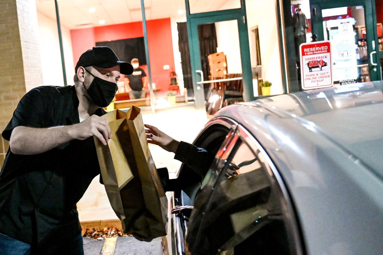 Regional manager Todd Niezgoski takes a Thanksgiving meal to family in need at the curbside pickup at Saddleback BBQ on Monday, Nov. 22, 2021, in Okemos. Customers donated 413 meals of the 926 that were distributed by Trinity Church or picked up at Saddleback's Okemos location. 