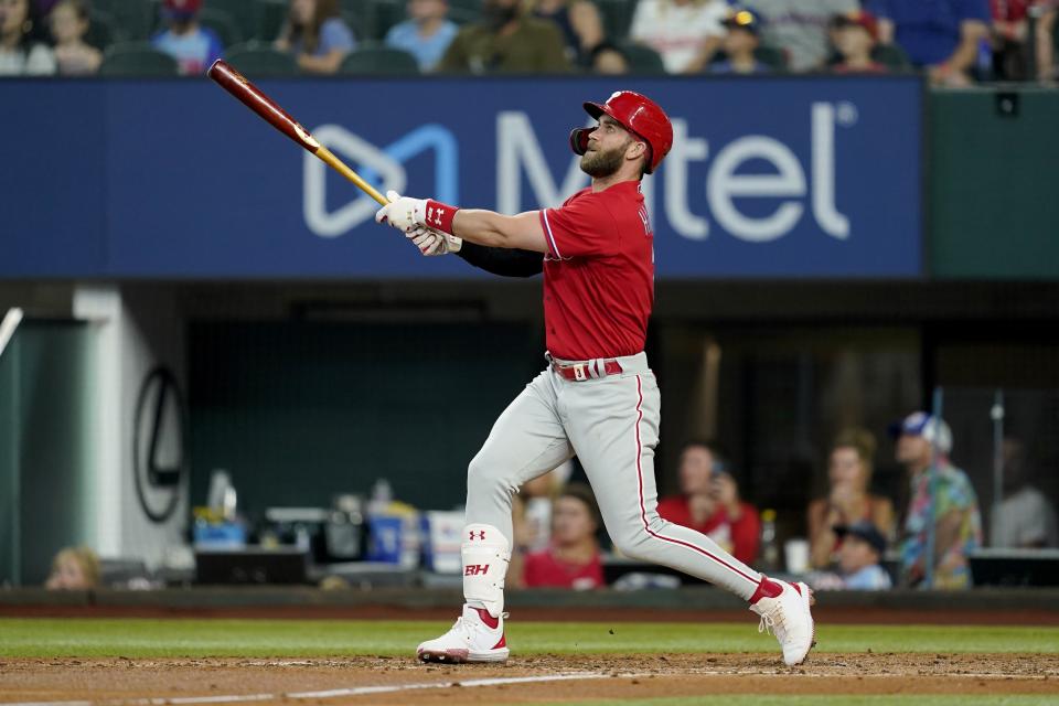 Philadelphia Phillies' Bryce Harper follows through on a fly out to center in the third inning of a baseball game against the Texas Rangers, Wednesday, June 22, 2022, in Arlington, Texas. (AP Photo/Tony Gutierrez)