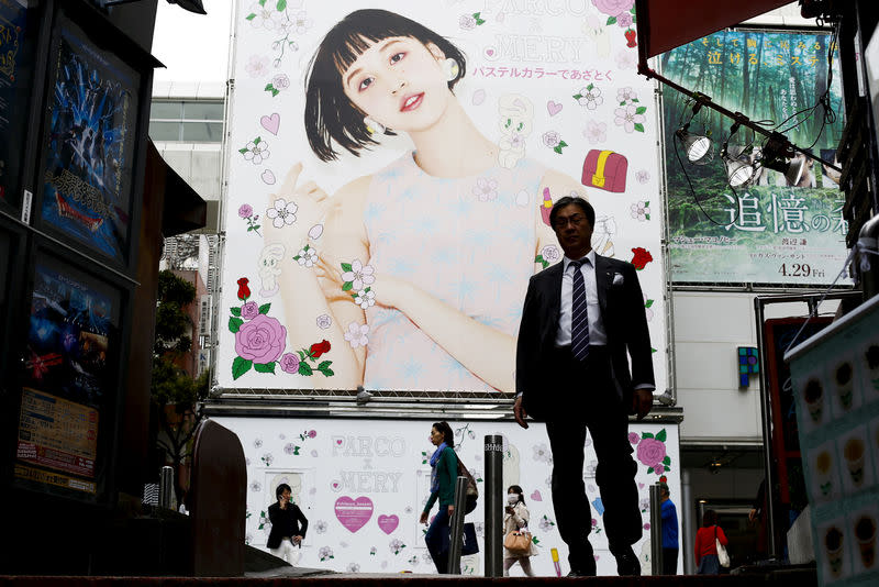 People walk past an advertising billboard in a shopping district in Tokyo, Japan, April 27, 2016. REUTERS/Thomas Peter/File Photo