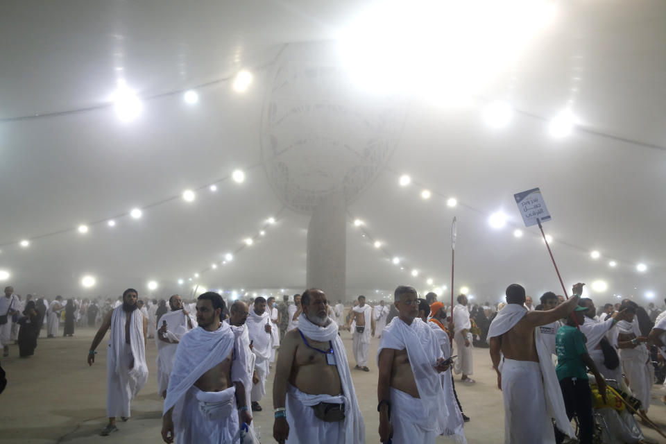 Muslim pilgrim walk after they cast stones at a pillar symbolizing the stoning of Satan, in a ritual called "Jamarat," the last rite of the annual hajj, on the first day of Eid al-Adha, in Mina near the holy city of Mecca, Saudi Arabia, Sunday, Aug. 11, 2019. The hajj is required of all Muslims to perform once in their lifetime if they are financially and physically able. (AP Photo/Amr Nabil)