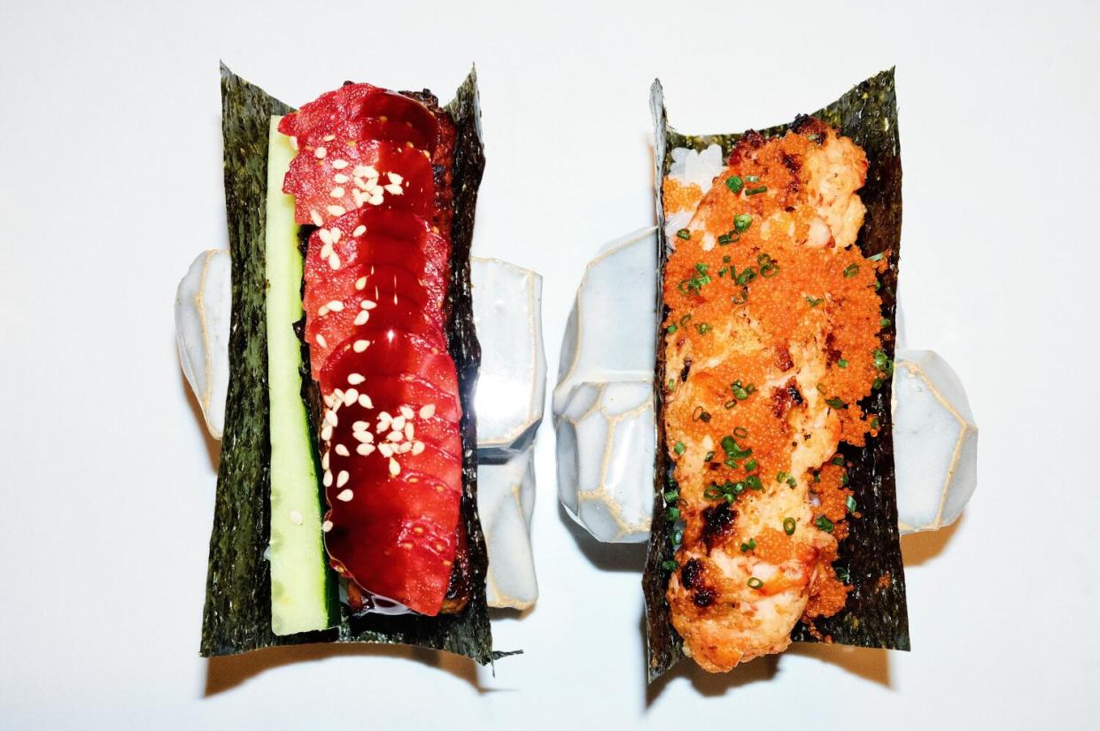 Two taco-shaped hand rolls on white marble at Norikaya: unagi with strawberry, left, and lobster dynamite with masago