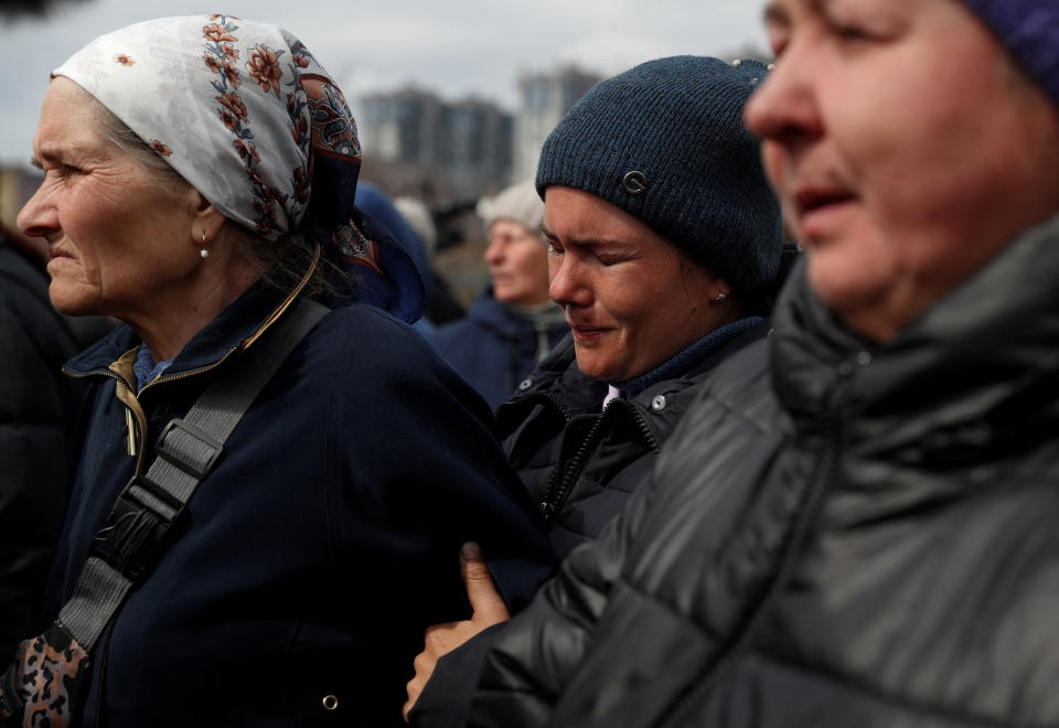 Local women react as they try to recognise their relatives among the bodies of civilians who Ukrainian officials say were killed during Russia's invasion and then buried in a mass grave in the town of Bucha, outside Kyiv, Ukraine April 8, 2022.  REUTERS/Valentyn Ogirenko