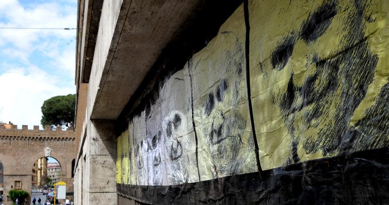 Portraits of popes Francis, John Paul II, and John XXIII by Italian street artist Maupal is seen in Rome near the Vatican on April 23, 2014