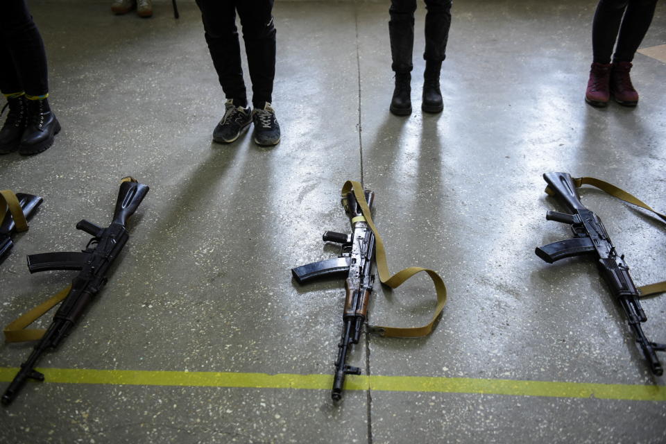 Rifles are seen lying on the ground as volunteers receive weapons training. 